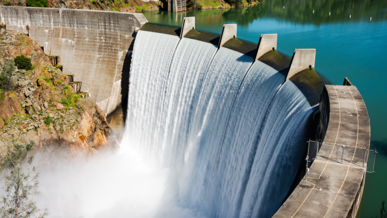 Concrete Dam with water spilling over from reservoir