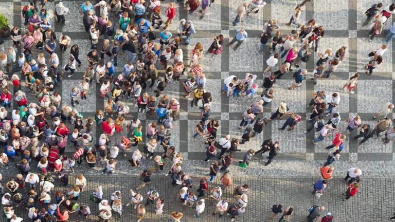 Aerial view of a concrete plaza with many people walking over it