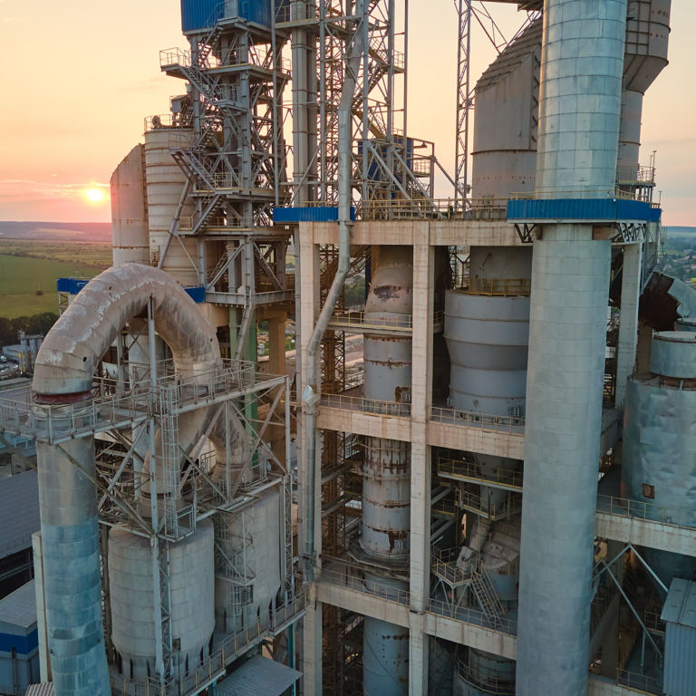 Close up shot of a cement plant with a sunset in the background