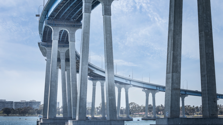 Large concrete bridge over a water way with tall stilt-like legs