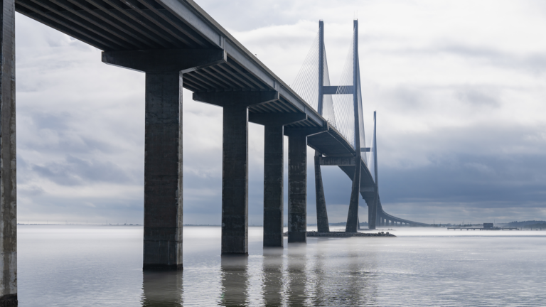 Concrete bridge over a bridge with storms behind it