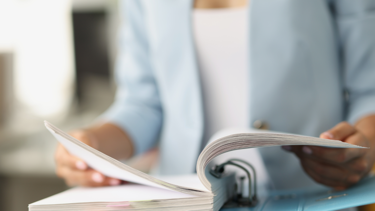 Woman examining information in folder with documents closeup